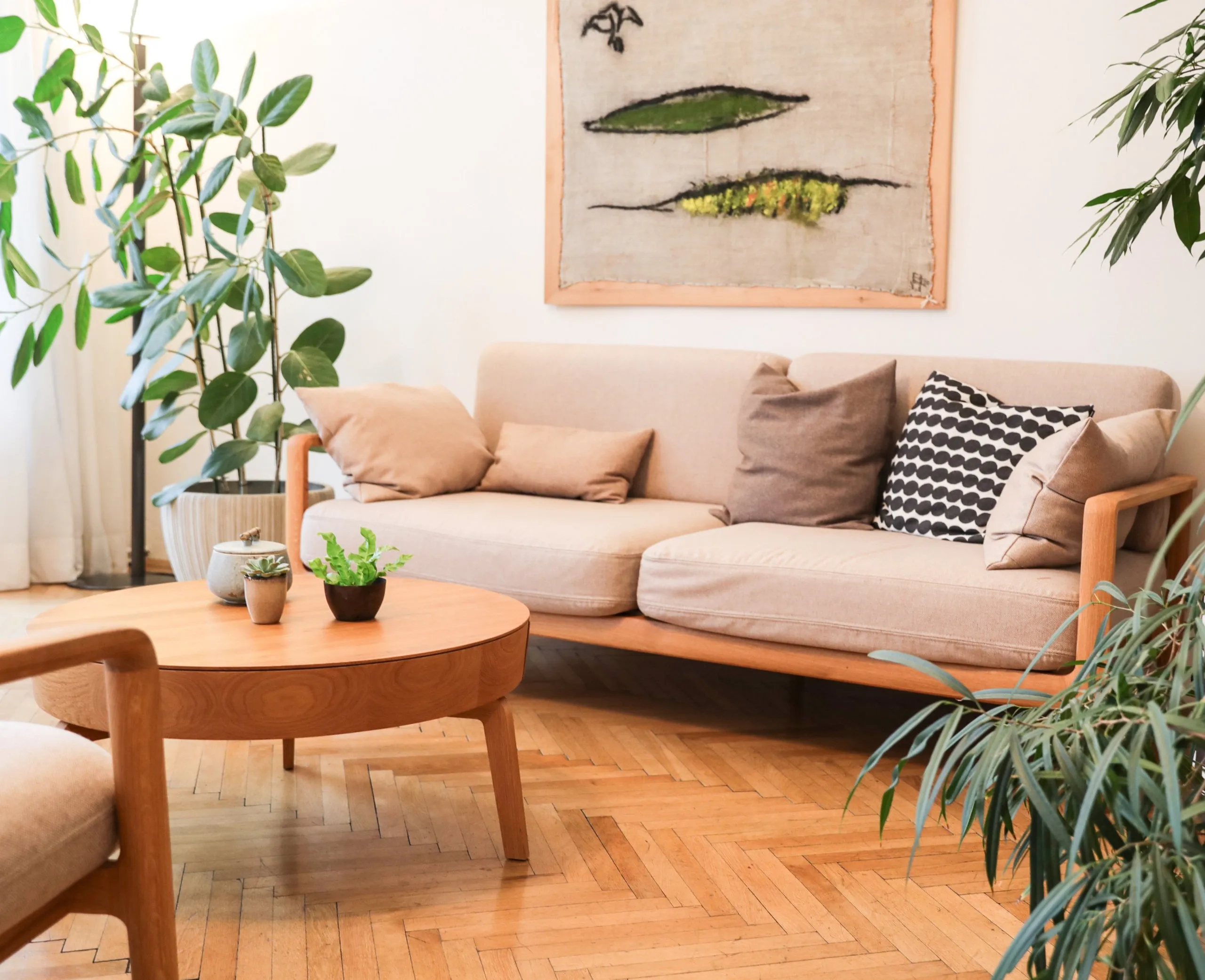 Praxisraum mit Sofa, rundem Tisch und Pflanzen